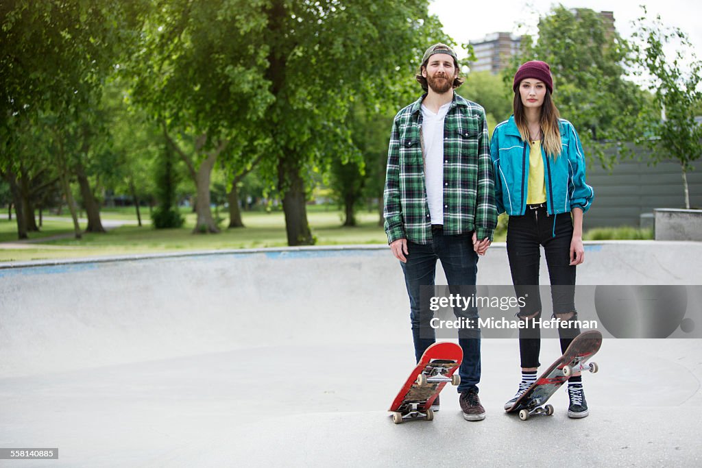 Portrait of young couple with skateboards