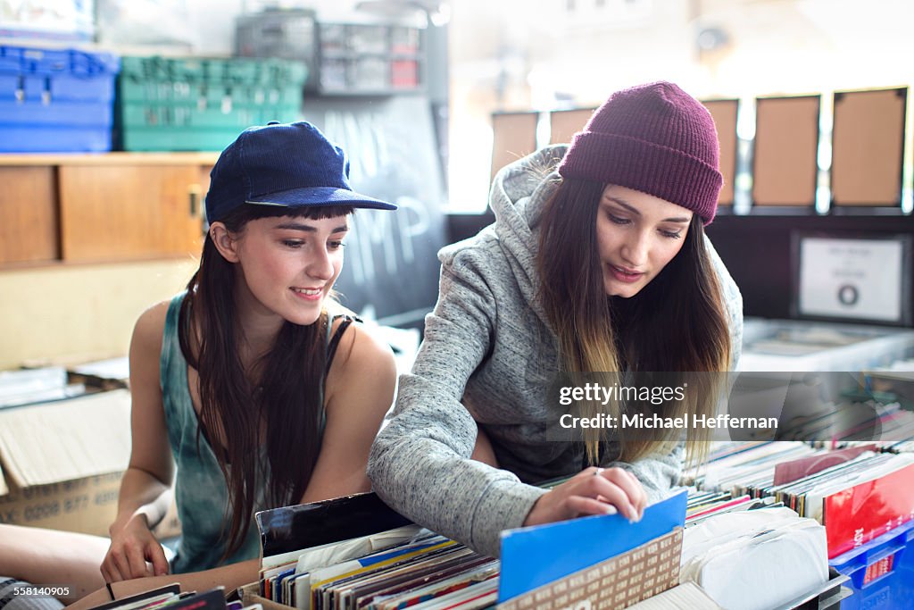 Two young women looking at records in store
