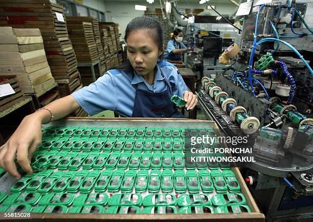 Photo prise le 18 decembre 2003 a Phatumthanee, au nord de Bangkok, d'une employee thailandaise travaillant sur une chaine d'assemblage de l'usine...