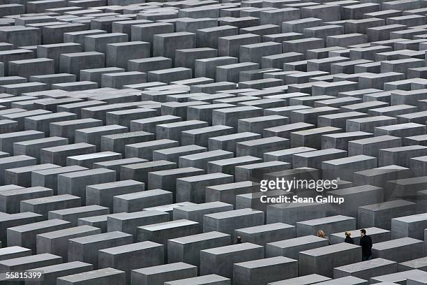 Visitors walk through the Holocaust Memorial by American architect Peter Eisenman May 12, 2005 in Berlin, Germany. Berlin is among cities that will...