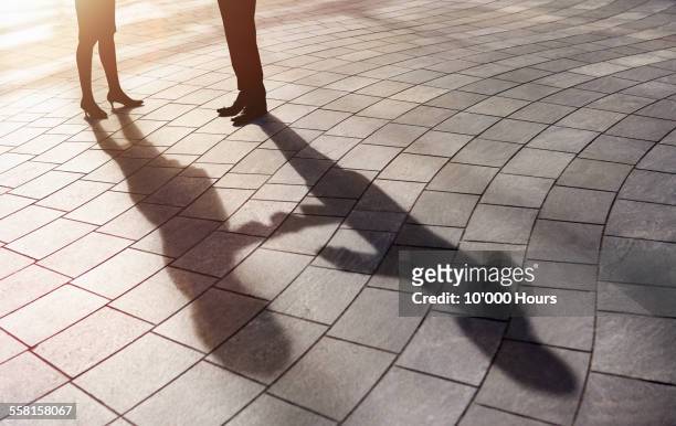 shadow of business people shaking hands - deal england stock-fotos und bilder
