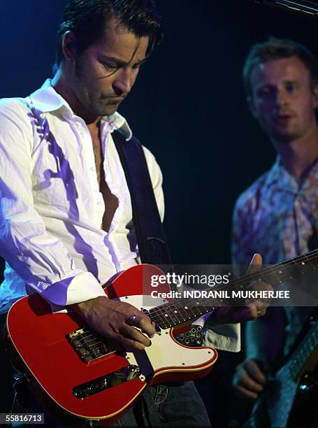 Musicians from Danish pop music group "Michael Learns to Rock" Kare Wanscher watches compatriot Mikkel Lentz performs during a concert in Mumbai, 28...