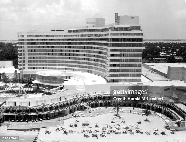 The Fontainebleau Hotel seen from the Easterly or oceanfront side shows cabanas and sunbathing areas adjacent to the beach, Miami Beach, Florida,...