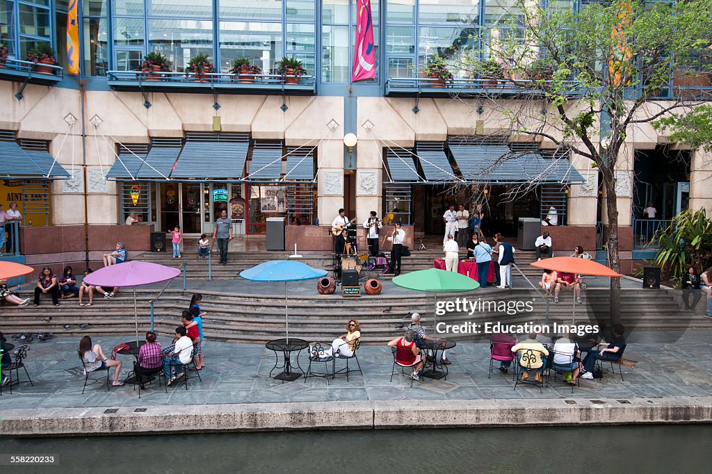 People sit outside the Rivercenter Mall on San Antonio's Riverwalk