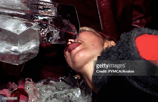 Girl drinking from a ice vodka luge, club, uk, 2000s.