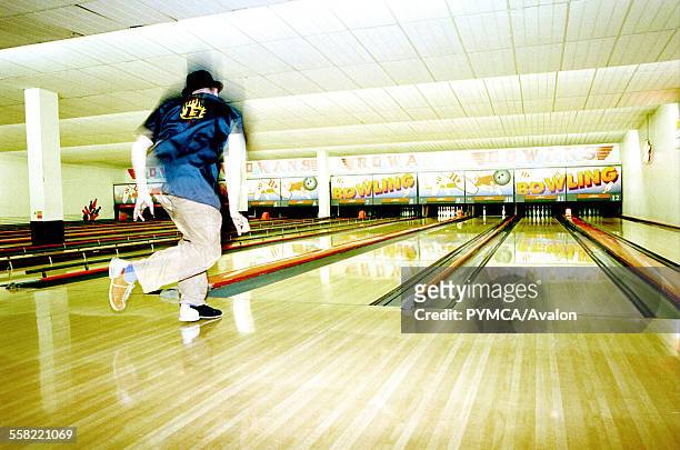 Man playing ten pin bowling, Wearing a hat, UK, 2000s.