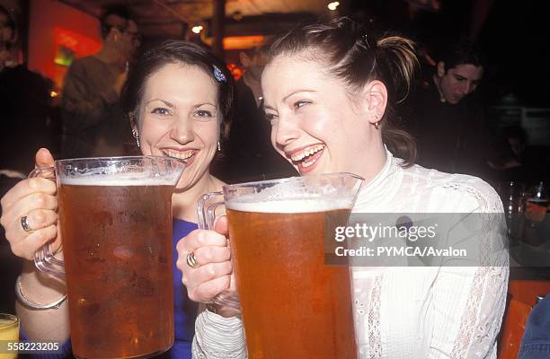 Two women laughing with big pints of beer, UK 2004.