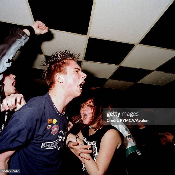 Rock fans dancing in a mosh pit. Manor Club, Chatham, Medway, Kent 2004 .