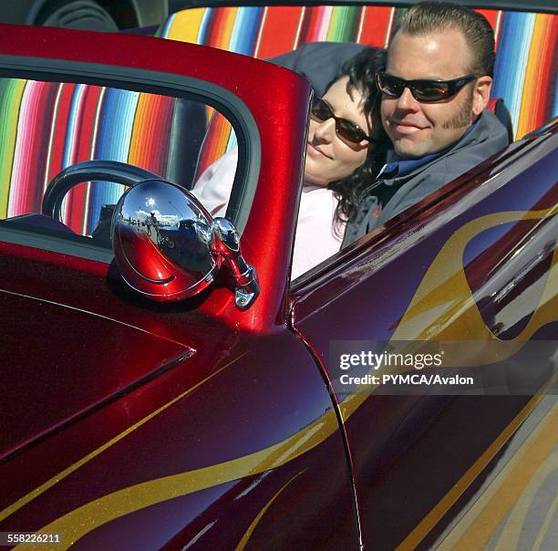 Couple of Rockabillies chilling in a 50s style car, a red Hotrod, Viva Las Vegas Festival, Las Vegas, USA 2006..