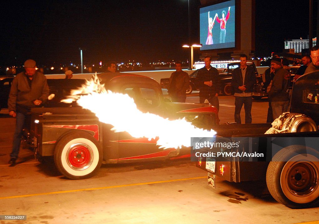A crowd of guys watching the flames coming out of the exhaust pipe of a customised Hotrod, Viva Las Vegas Festival, Las Vegas, USA 2006