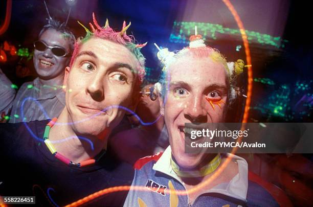 Two male clubbers looking into camera with neon hair and wide eyes. Slinky at BIC in Bournmouth 1999.