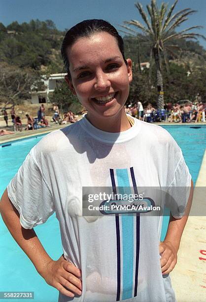 Holiday reps in Ibiza, holiday rep beside outdoor swimming pool, smiling with hands on hips, wet tshirt, Club 1830, Ibiza 2001.