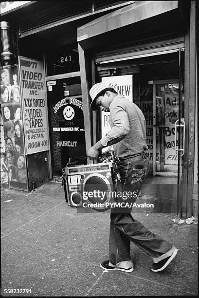 Man walking down the street with his ghetto blaster in his hands, New York, USA, 1980.