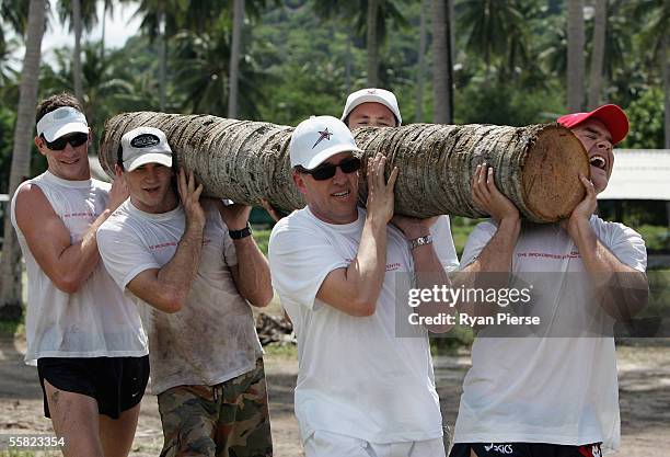 Ben Holland, David Neitz, Paul Gardiner and Brad Green carry a log while helping to build the The Broadbridge Education Centre during the Melbourne...