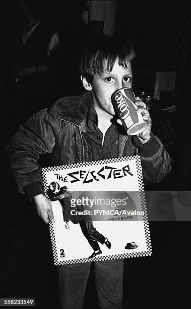 Young boy holding a Selecter album, drinking Coca Cola, Ska, 2 Tone, Coventry, UK 1980.