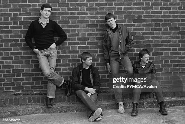 Teenage friends pose up against a brick wall in 1980. UK 1980.