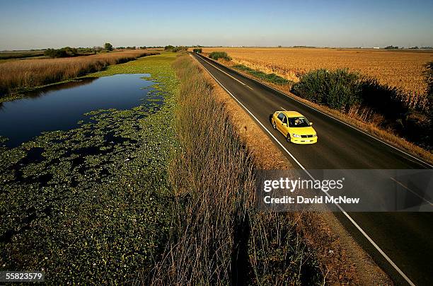 Water is held back from a lower-elevation farm by a section of Highway 4 that serves as a levee road in the Sacramento-San Joaquin River Delta, on...