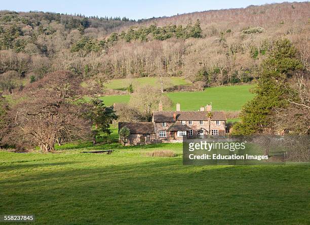 Exmoor farmhouse set amongst trees Brandish Street hamlet, Selworthy, Somerset, England