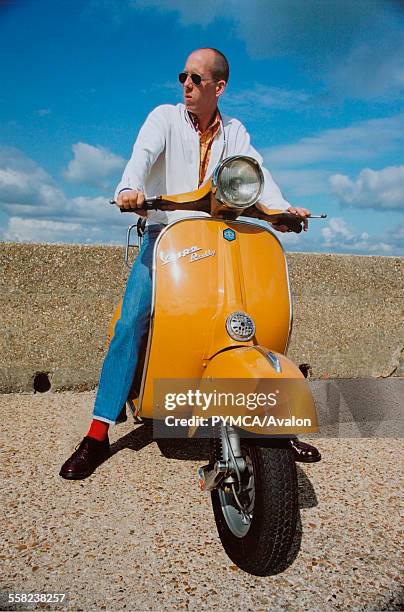 Mod sitting on a yellow scooter, 2000s.