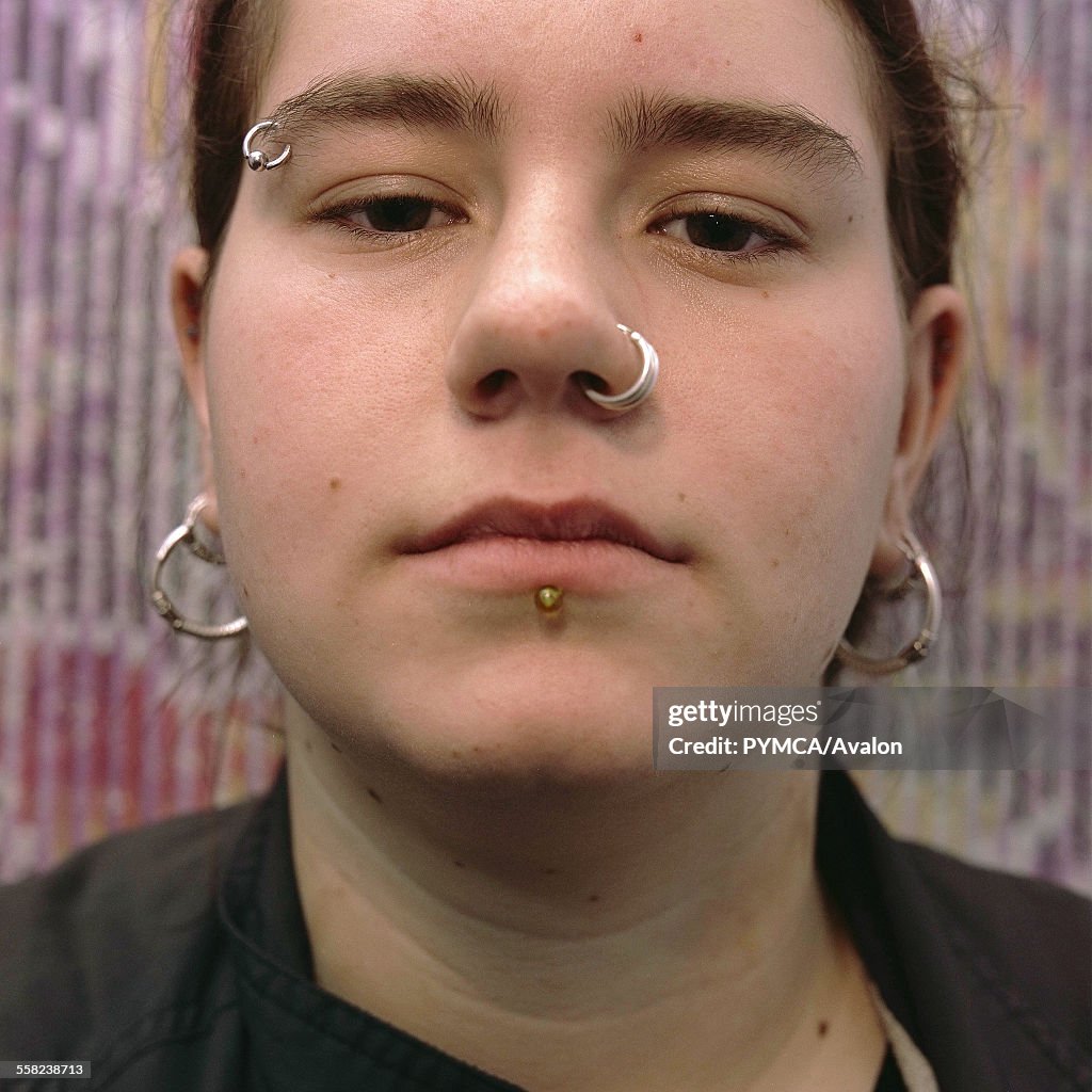 Portrait of a teenage girl with piercings on her lip, eyebrow and