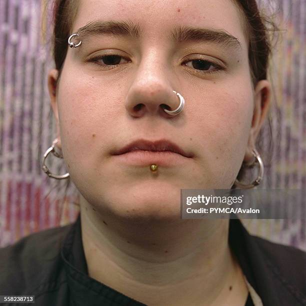 Portrait of a teenage girl with piercings on her lip, eyebrow and nose, Cardiff 2000s.