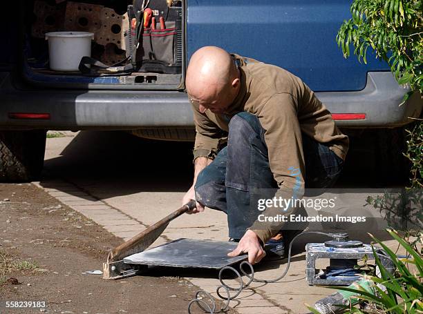 Builder cutting a tile, Cornwall