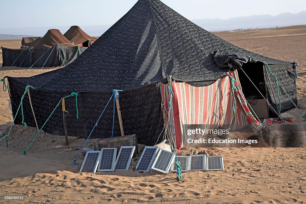 Portable solar panels used to produce electric power outside a traditional Berber nomads tent