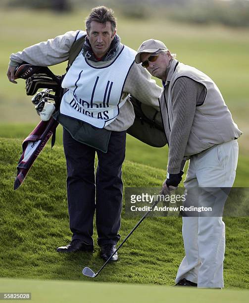 Actor Michael Douglas lines up to play a chip shot to the 16th green during the first round of the Dunhill Links Championships at the Carnoustie Golf...