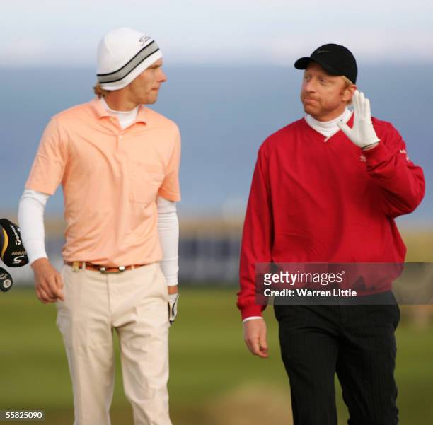 Marcel Siem speaks with countryman and tennis star Boris Becker on the 18th hole during the first round of the Dunhill Links Championship on...