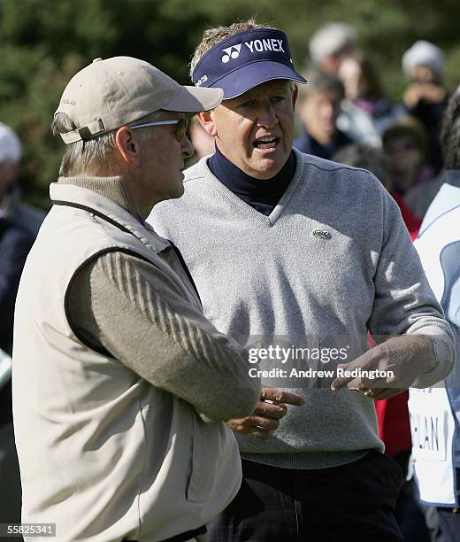 Actor Michael Douglas talks with his playing partner Colin Montgomerie of Scotland during the first round of the Dunhill Links Championships at the...