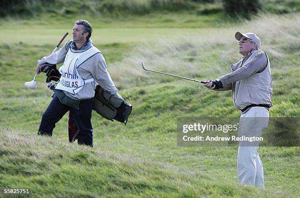 Actor Michael Douglas plays his third shot at the 16th hole during the first round of the Dunhill Links Championships at the Carnoustie Golf Club,...