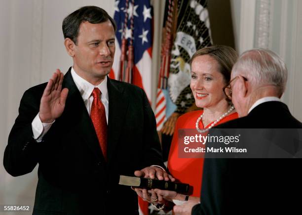 Jane Roberts holds a Bible as John Roberts raises his right hand as he is sworn in as Chief Justice of the United States Supreme Court by Associate...