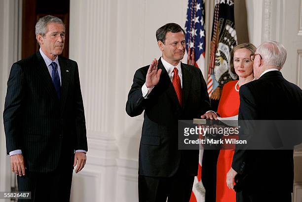 Jane Roberts holds a Bible as John Roberts is sworn in as Chief Justice of the United States Supreme Court by Associate Justice John Paul Stevens...