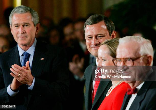 President George W. Bush applauds as John Roberts is welcomed to the East Room prior to being sworn in as Chief Justice of the United States Supreme...