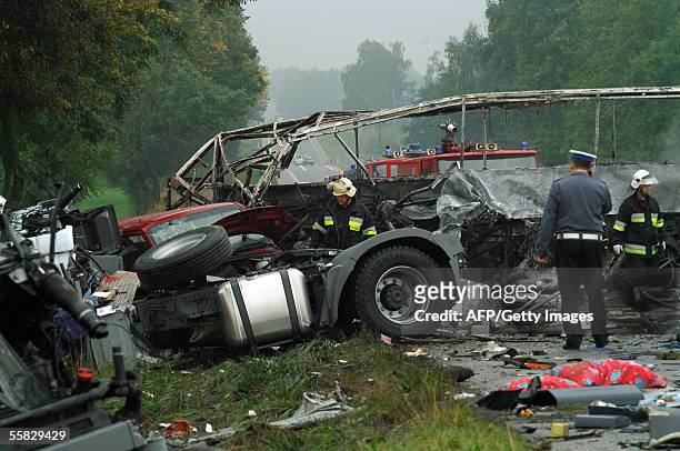 Firemen check the wreckage of a crashed and burned bus after an accident near Jezewo, northeastern Poland, 30 September 2005. At least 11 people died...