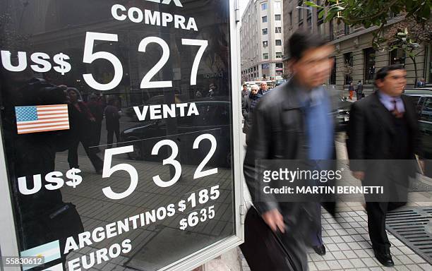 Transeuntes pasan junto a la pizarra de un cambio que indica el valor del dolar, en el centro de Santiago, el 30 de septiembre de 2005. El peso...