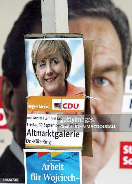 Posters of German Chancellor Gerhard Schroeder of the Social Democrats party and of Angela Merkel, leader of the Christian Democratic Union party and...