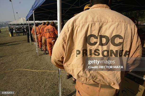 Simi Valley, UNITED STATES: Inmates from surrounding prisons line up after working to contain a wildfire in Simi Valley, CA 30 September 2005. An...