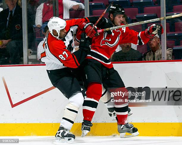 Defenseman Colin White of the New Jersey Devils gets tangled with left wing Donald Brashear of the Philadelphia Flyers during a preseason game at the...