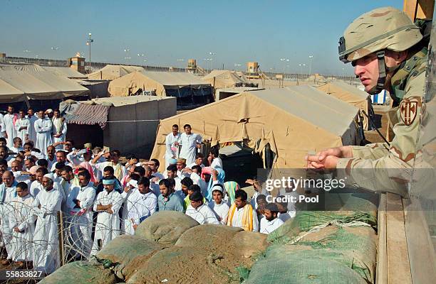 Soldier watches as detainees are released on October 1, 2005 from Abu Ghraib prison, 25 kms west of Baghdad. About 500 Iraqi prisoners were released...