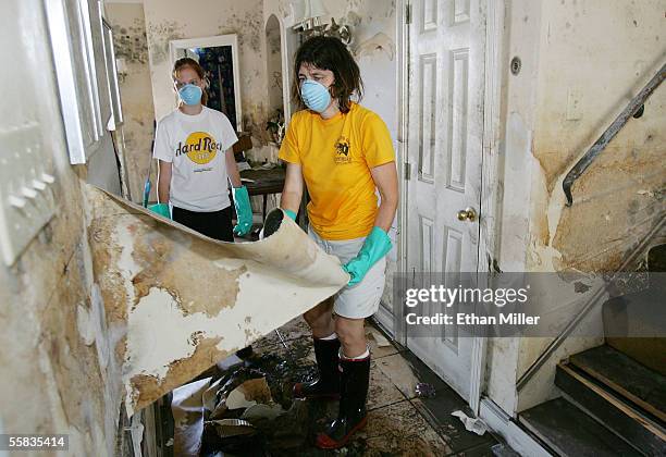 Amanda Barrett , 18-years-old, watches her mother Eve Barrett peel a mold-covered layer of paint off a wall as the family sees what is left of their...