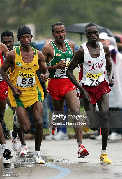 Fabiano Joseph Naasi of Tanzania runs alongside Mubarak Hassan Shami of Quatar and Abebe Dinkesa Negera of Ethiopia in the men's event during the...