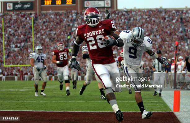 Running back Adrian Peterson of the Oklahoma Sooners runs for a touchdown past Kyle Williams of the Kansas State Wildcats on October 1, 2005 at...