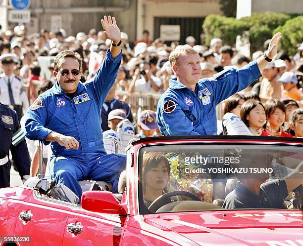 Space Shuttle Discovery crew members Charles Camarda of the US and Andrew Thomas of Australia wave to a crowd of people from a convertable during a...