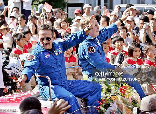 Space Shuttle Discovery crew members Charles Camarda of the US and Andrew Thomas of Australia wave to a crowd of people from a convertable during a...