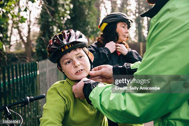 family going on a bicycle ride - father helping son wearing helmet stock pictures, royalty-free photos & images