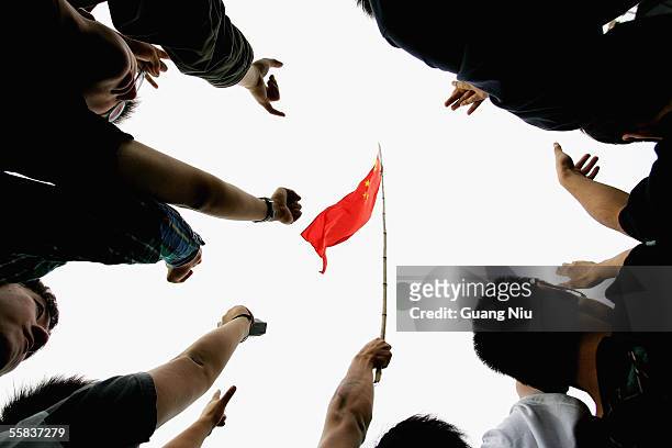 China's national flag is flown during a rock-and-roll festival to mark Chinese National Day on October 2, 2005 in Beijing, China. Various activities...