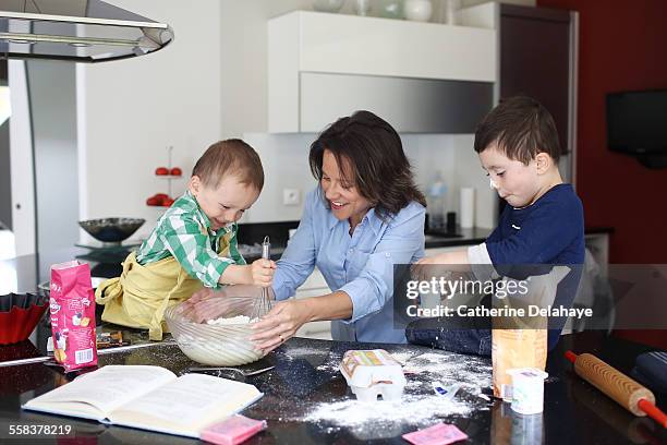 a mom cooking with her 2 boys - anarchist cookbook stock pictures, royalty-free photos & images
