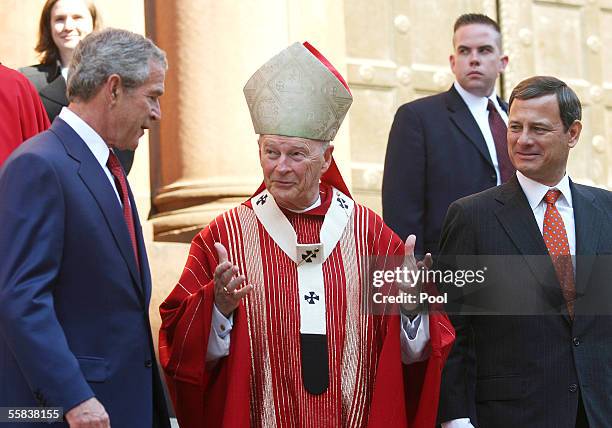 President George W. Bush speaks with Cardinal Theodore McCarrick, Archbishop of Washington, as new Chief Justice John Roberts looks on, after the...