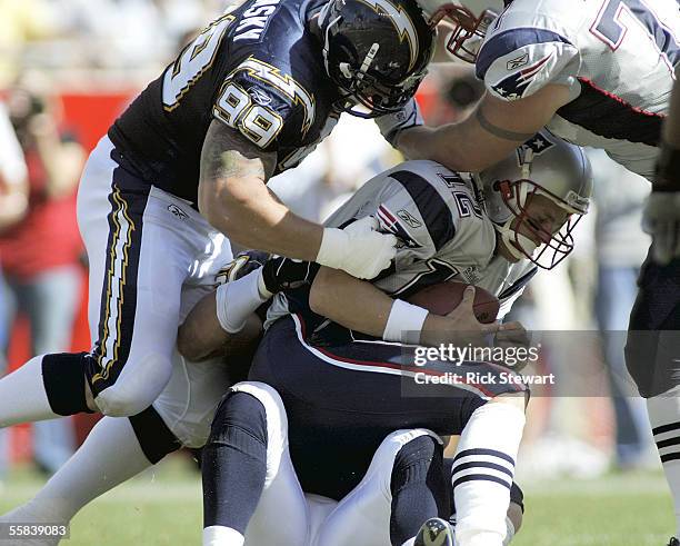 Quarterback Tom Brady of the New England Patriots gets sacked by linebacker Ben Leber and defensive tackle Igor Olshansky of the San Diego Chargers...